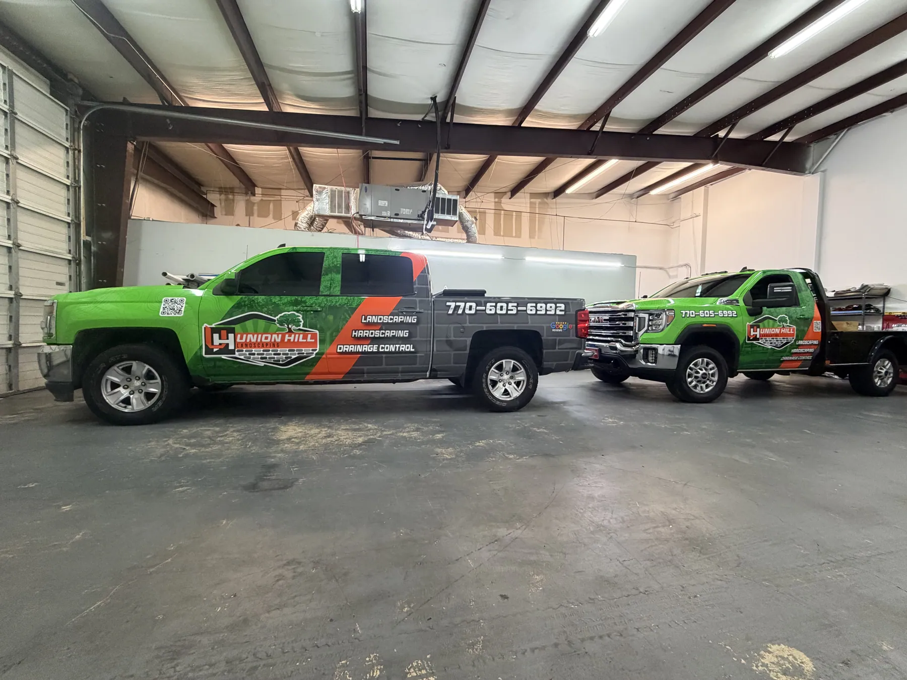 Matching branded green commercial trucks in a workshop