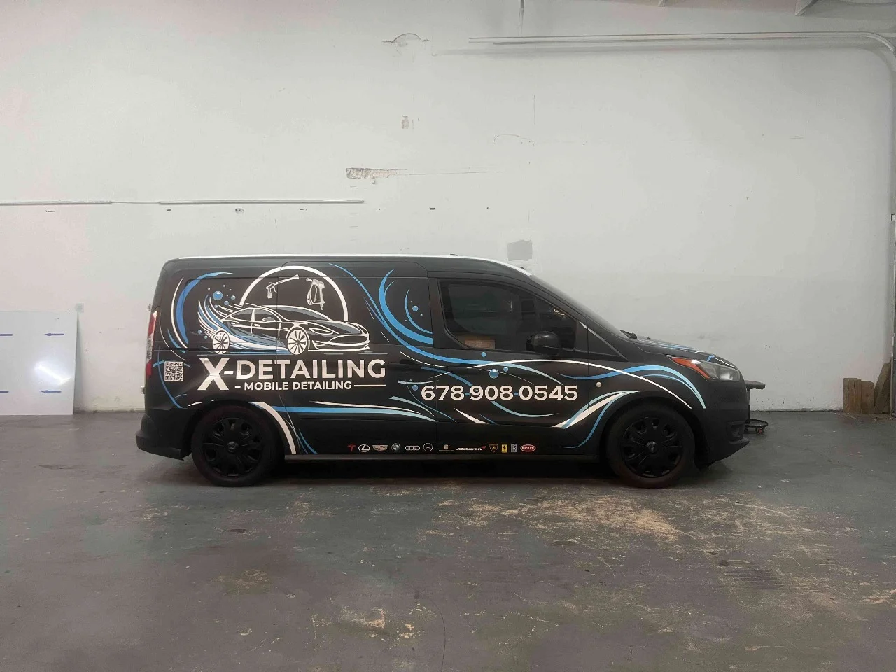 Black X-Detailing service van with a custom wrap